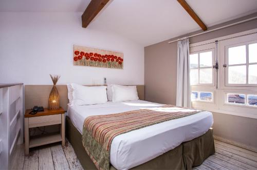a bedroom with a large bed and a window at Ciribaí Praia Hotel in Pauba