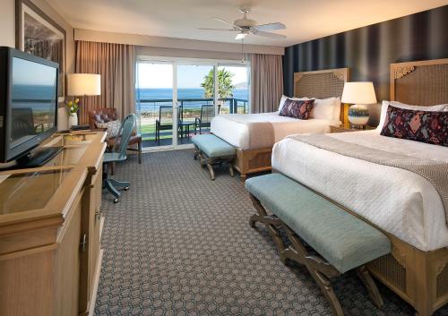 um quarto de hotel com duas camas e uma televisão de ecrã plano em Spyglass Inn em Pismo Beach