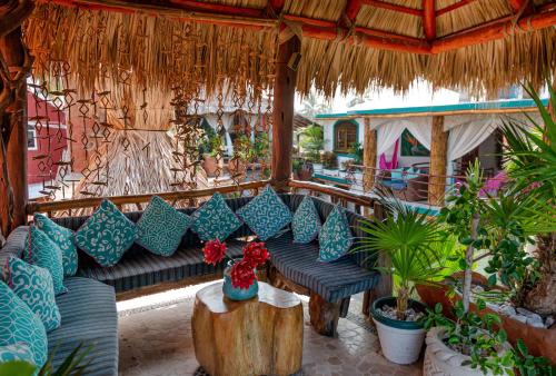 an outdoor seating area with a couch and plants at Monyoli Hotel & Boutique in Acapulco