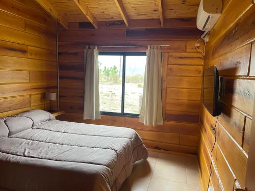 1 dormitorio con cama y ventana en Complejo Anthea en Villa Yacanto