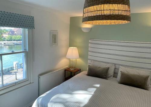 1 dormitorio con 1 cama con ventana y lámpara en Bristol townhouse with harbour views. Sleeps 7 en Bristol