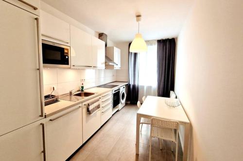 a kitchen with white cabinets and a table and a sink at Apartment in the heart of Berlin 2122 in Berlin