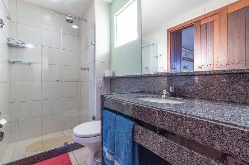 a bathroom with a sink and a toilet and a mirror at Condomínio Blue Marlim por Carpediem in Parnamirim
