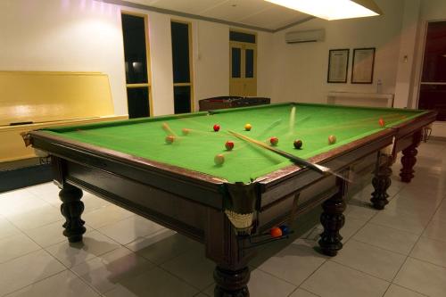 a pool table with balls on it in a room at Equator Village Maldives in Gan