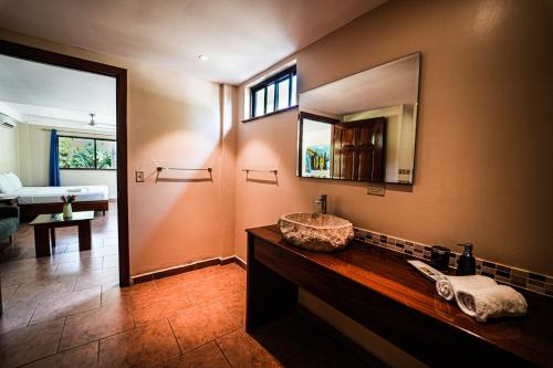 een badkamer met een wastafel en een spiegel bij Sol y Sombra in Bocas del Toro