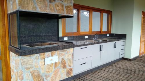 uma cozinha com um lavatório e uma bancada em Casa de luxo em Monte Verde em Camanducaia