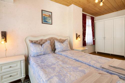 - une chambre avec un lit et une couette bleue dans l'établissement ВИЛА ТЪРТЕФФ, à Nessebar