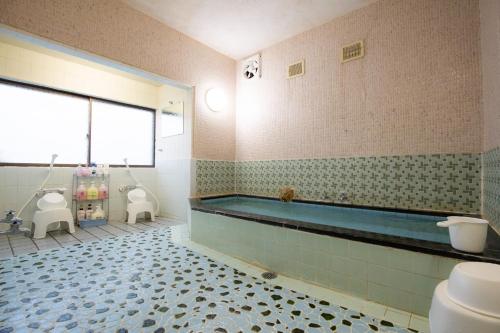 La salle de bains est pourvue d'une baignoire et de toilettes. dans l'établissement Ichimaru Ryokan - Vacation STAY 59281v, à Tenkawa