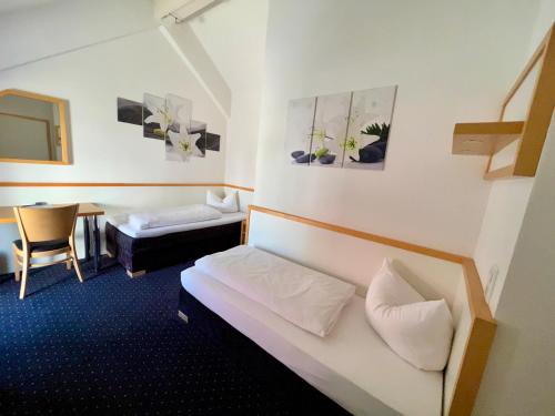 a hotel room with a bed and a table at otto - bed & breakfast in Ottobeuren