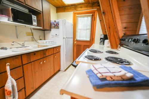 een keuken met een fornuis en een wastafel bij Rustic Cabin 1 - Three Bedroom in Forest Lakes Estates