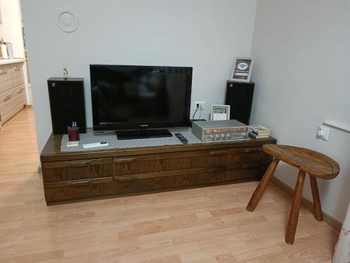 a living room with a tv and a chair and a table at Apartmani Janjic in Banja Luka