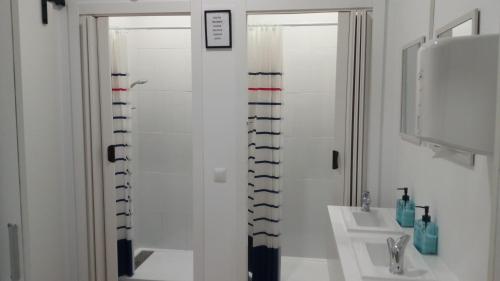 a white bathroom with a shower and a sink at Fonte dos aloques in Porriño