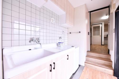 a white bathroom with a sink and a tub at BRUCE HOUSE - Vacation STAY 9370 in Izumi-Sano