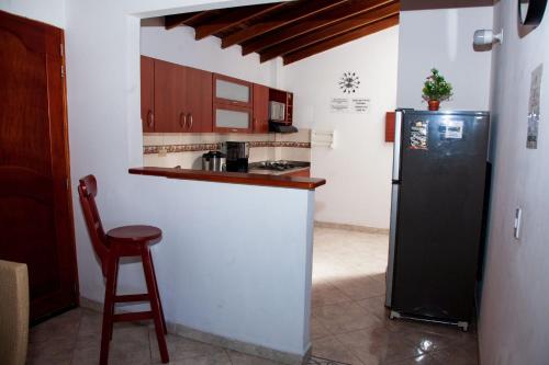 a kitchen with a black refrigerator and a stool at Apartamento en Envigado in Envigado