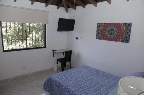 Dormitorio con cama, escritorio y TV en Apartamento en Envigado, en Envigado