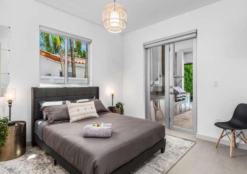 una camera con letto, sedia e finestre di Exotic 5 Bedroom Villa In South Miami a Miami