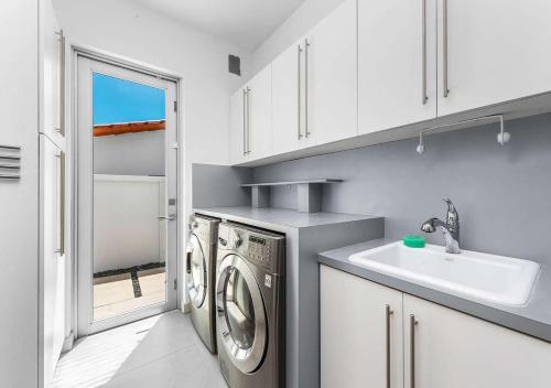 una cucina con lavatrice e lavandino di Exotic 5 Bedroom Villa In South Miami a Miami