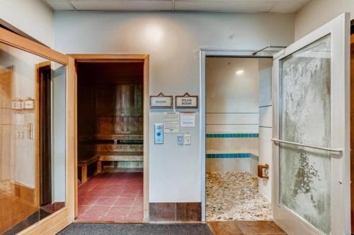 un couloir avec une porte menant à une chambre avec un piano dans l'établissement Bluegreen's StreamSide at Vail, à Vail