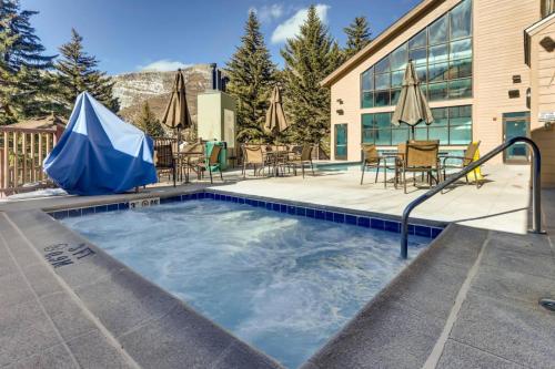 a swimming pool with chairs and umbrellas next to a building at Bluegreen's StreamSide at Vail in Vail
