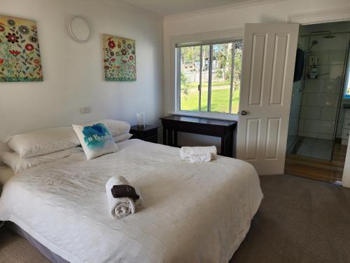 a bedroom with two beds and a bathroom with a shower at A Slice of Paradise in Barnes Bay
