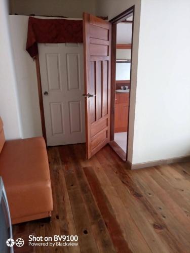 an open door in a room with wooden floors at Casa del Campo in Tela