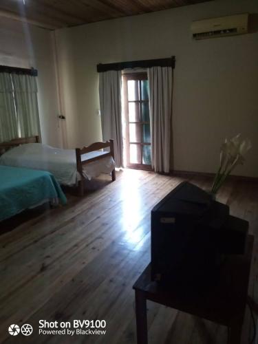 a bedroom with a bed and a window and a tv at Casa del Campo in Tela
