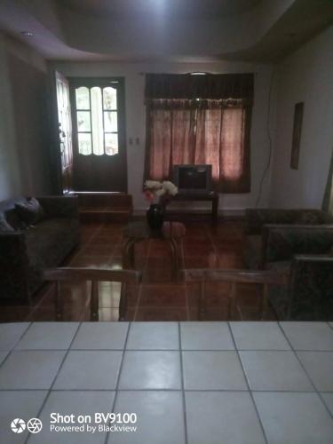a living room with a couch and a tv at Casa del Campo in Tela
