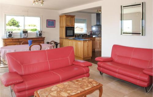 un salon avec des canapés rouges et une cuisine dans l'établissement Holiday Home La Digue, à Kerlouan