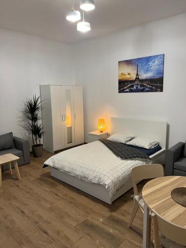 a bedroom with a bed and a table and chairs at Paris Apartments in Katowice