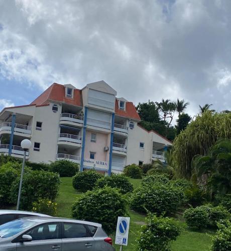 a building with a car parked in front of it at f3 location saisonnière détente tranquillité et belle vue in Les Trois-Îlets