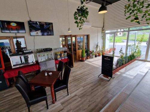 a restaurant with a table and chairs and a counter at Apartmani BJELASICA in Bijelo Polje