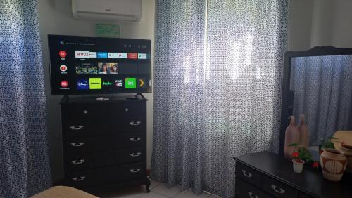 a bedroom with a dresser and a window with curtains at Beach One Bedroom 2 in Ocho Rios