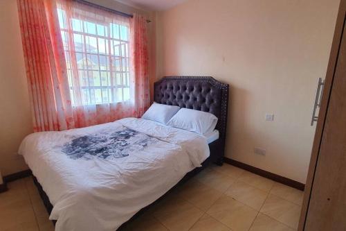 a bedroom with a large bed with a window at Spacious 2bedroom condo w free parking on premises in Nairobi