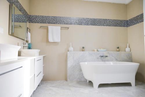 a bathroom with a white tub and two sinks at Atlantic Luxury Apartments in Bakau