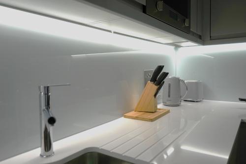 eine Küchentheke mit einem Messerblock und einer Spüle in der Unterkunft Exceptional 1King Lifestyle Apartment - Centrally located in Birmingham