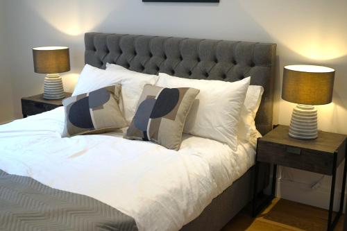 ein großes Bett mit zwei Lampen an zwei Tischen in der Unterkunft Exceptional 1King Lifestyle Apartment - Centrally located in Birmingham