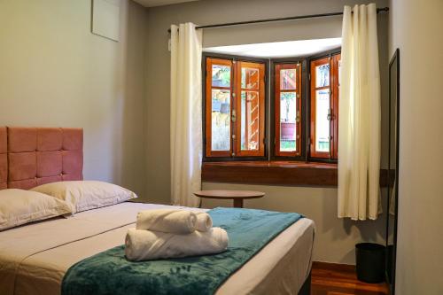 a bedroom with two beds and a window at Hostel Jardim das Bruxas 410 in Florianópolis