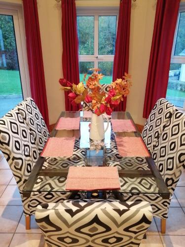 a dining room table with a vase of flowers on it at Rosswood House in Donegal