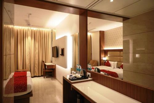 - une chambre d'hôtel avec un lit et une baignoire dans l'établissement Hotel Gurudev Grand, à Kalyan