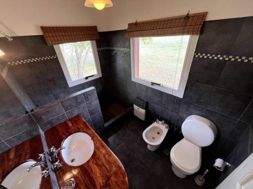 un baño con lavabo e inodoro en El Lucero, estancia, en Mar de Ajó