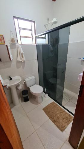 een badkamer met een douche, een toilet en een wastafel bij Casa Sol Brilhante - natureza e riacho na varanda in Gonçalves
