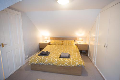 a bedroom with a bed with yellow sheets and yellow pillows at Sandgate 2-Bed Apartment in Ayr central location in Ayr