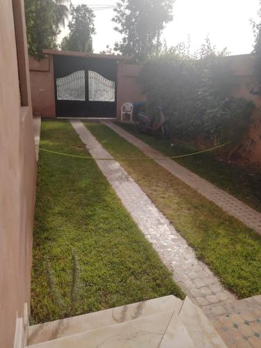 a backyard with a lawn with a hose at Luxurious Moroccan Villa Discover the Magic of Moorish Design in Marrakesh