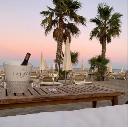 a bottle of wine sitting on a table on a beach at Litchi in Canet-en-Roussillon