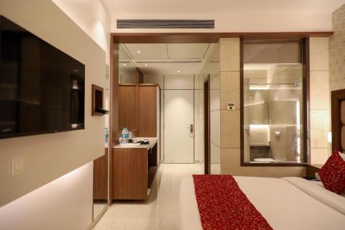 a hotel room with a bed and a bathroom at Hotel Gurudev Grand in Kalyan
