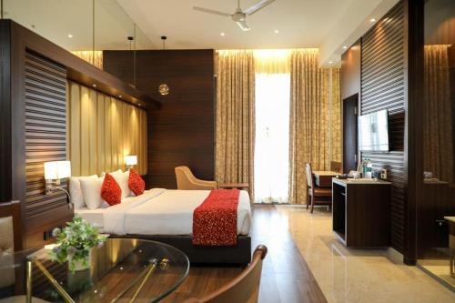 a hotel room with a bed and a desk at Hotel Gurudev Grand in Kalyan