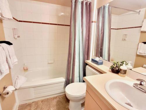 a bathroom with a sink and a toilet and a bath tub at Horsethief Lodge by FantasticStay in Panorama