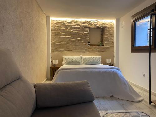 a bedroom with a large bed and a couch at Plaza Adarve Toledo in Toledo