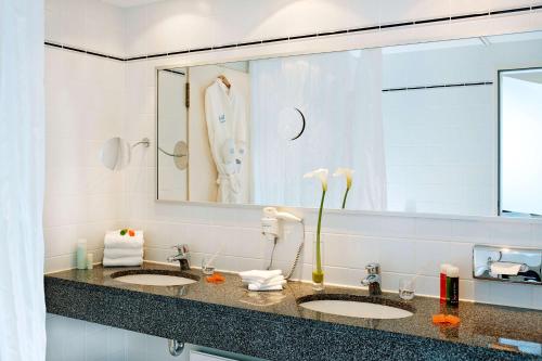 La salle de bains est pourvue de 2 lavabos et d'un grand miroir. dans l'établissement Hotel Klösterle Nördlingen, à Nördlingen