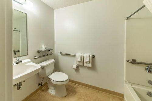 a white bathroom with a toilet and a sink at Studio 6 Greensboro NC I40 in Greensboro